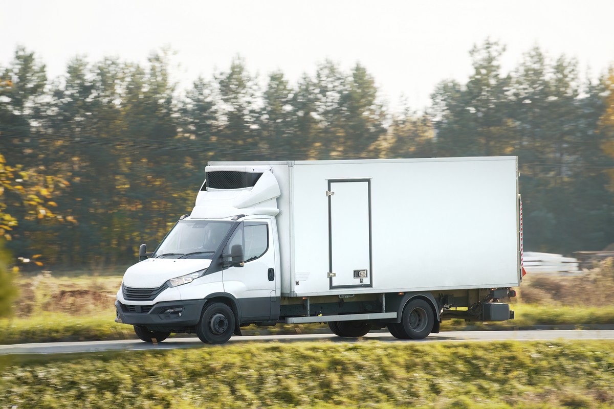delivery van. A mockup of a white commercial vehicle isolated on the road. Perfect for your business and shipping needs.