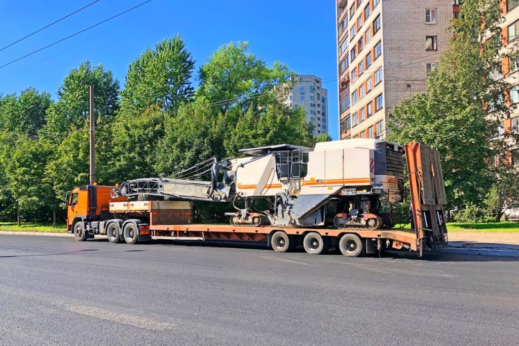 Transportation of equipment for cutting and removing old asphalt pavement for road repair truck platform of a truck trailer on highway in a city