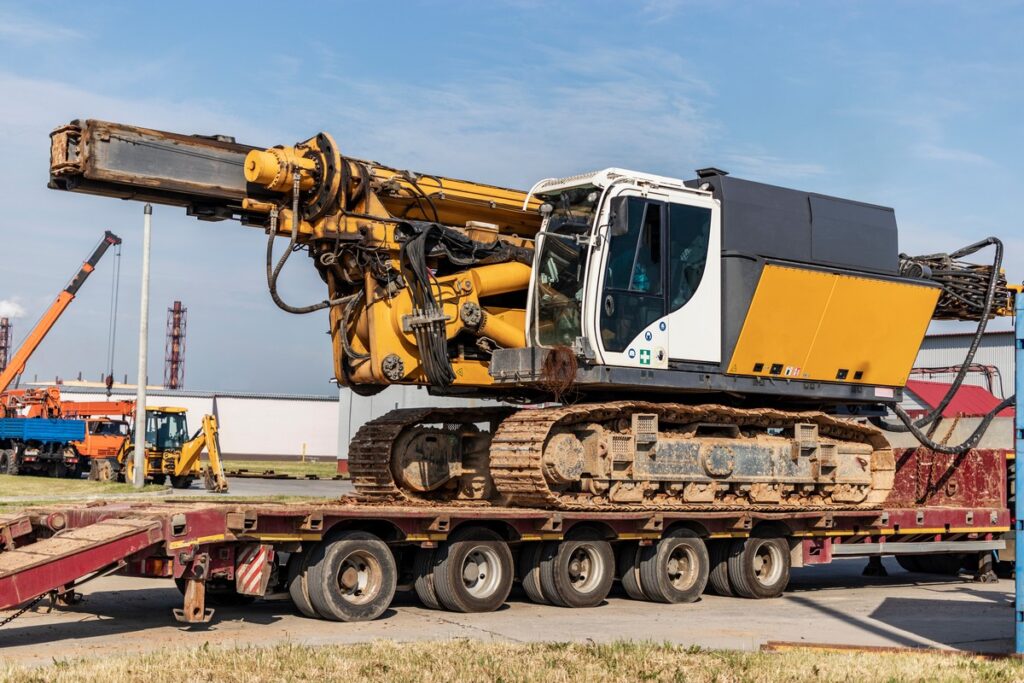 Loading of a drilling rig for the installation of bored piles onto a trawl for transportation to the place of work. Powerful construction machine. Pile foundations